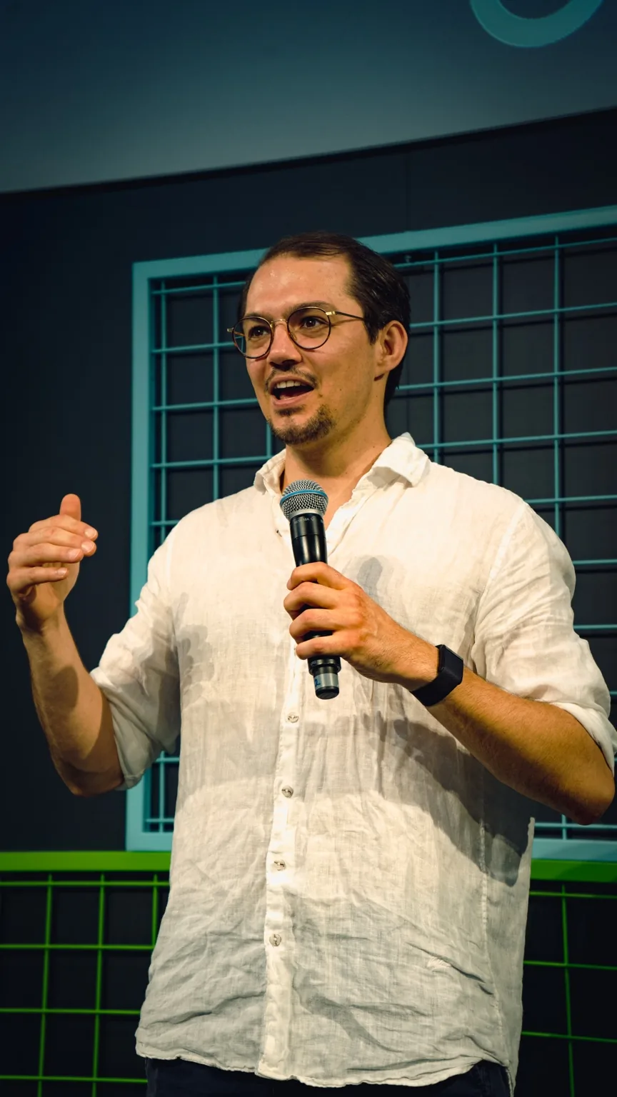 Johannes Hase bei einer Moderation mit Mikrofon.
